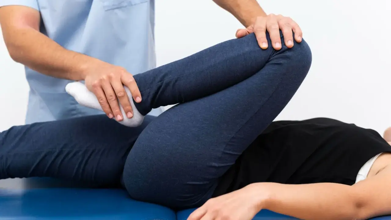 Fizjoterapeuta bada nogę pacjenta, sprawdzając zakres ruchu. Może to pomóc w diagnozie stłuczenia biodra objawy.