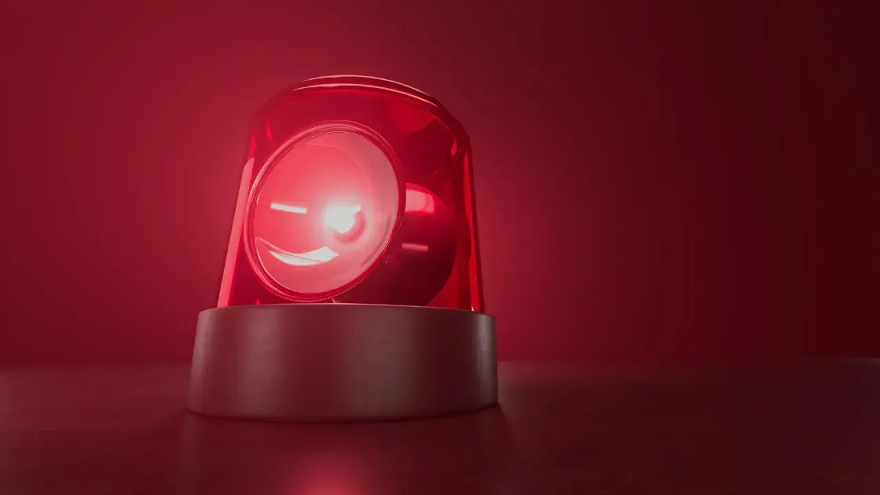 Czerwona lampa ostrzegawcza miga, jakby wzywała do pilnego działania. Jej światło rozchodzi się w czerwonej mgle, przypominając o czymś ważnym, niczym bociani chód zapowiadający zmiany.