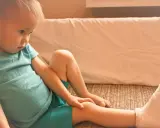 Smutny chłopiec z gipsem na nodze po skręceniu kostki. Jak długo nie można chodzić po urazie?