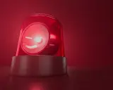 Czerwona lampa ostrzegawcza miga, jakby wzywała do pilnego działania. Jej światło rozchodzi się w czerwonej mgle, przypominając o czymś ważnym, niczym bociani chód zapowiadający zmiany.