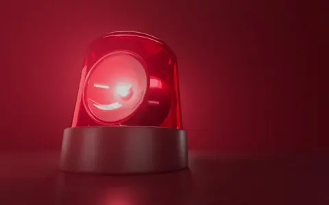 Czerwona lampa ostrzegawcza miga, jakby wzywała do pilnego działania. Jej światło rozchodzi się w czerwonej mgle, przypominając o czymś ważnym, niczym bociani chód zapowiadający zmiany.