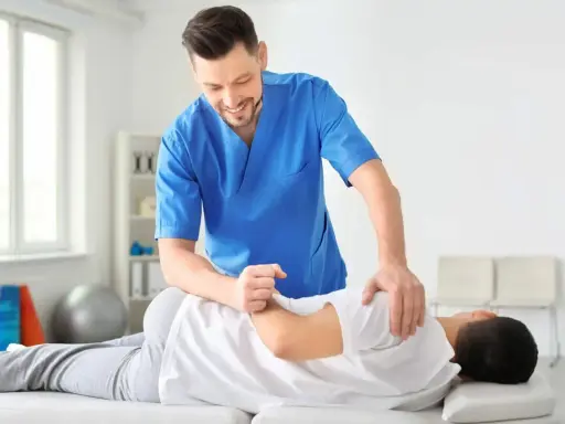 Fizjoterapeuta wykonuje masaż pleców pacjenta. To pokazuje, czym jest fizjoterapia: pomoc w powrocie do zdrowia i sprawności.