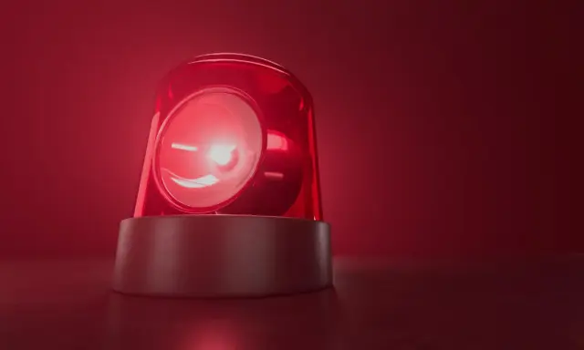 Czerwona lampa ostrzegawcza miga, jakby wzywała do pilnego działania. Jej światło rozchodzi się w czerwonej mgle, przypominając o czymś ważnym, niczym bociani chód zapowiadający zmiany.
